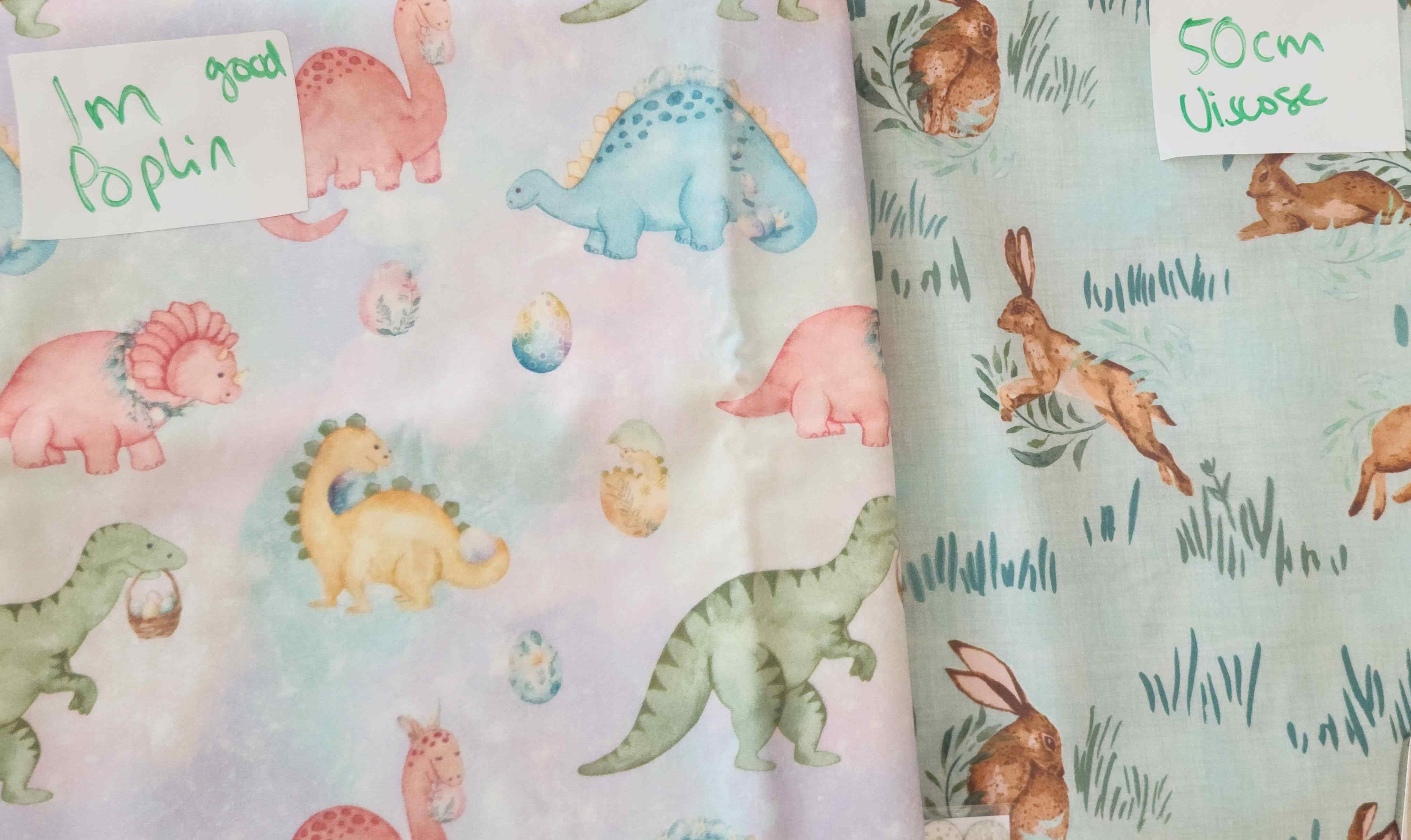 Fabric with colorful dinosaur pattern and brand label on a white background